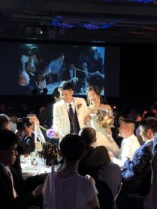 笑顔でテーブルラウンドを行う新郎新婦