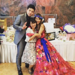 司会者の金城真知子と新郎新婦で記念撮影
